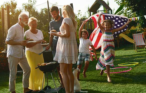 Family celebrating the holiday and grilling in their backyard.